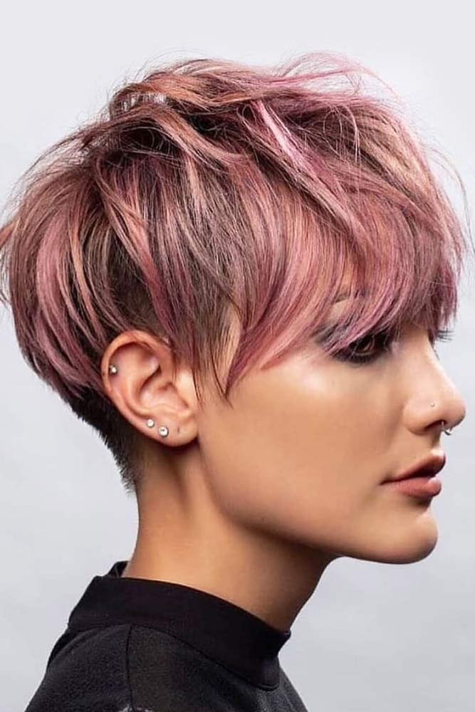 This haircut features subtle side part and wispy bangs to frame the jawline beautifully while showing off jagged cut layers throughout sides and back of simple length which enhances shape. Messy Long Shaved Pixie #pixiecut #haircuts #longpixie #shorthair